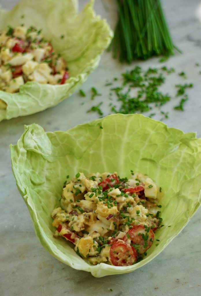 Krämig äggsallad serverad i ett skålformat savoykålsblad